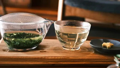 Green tea leaves and L-theanine supplement capsules on a table