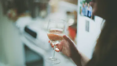 Wine glass and water glass side by side on a bar, representing alcohol and UTI risk choices