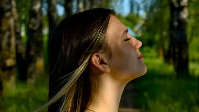 Woman practicing deep breathing in a park, a calming technique for anxiety and overactive bladder