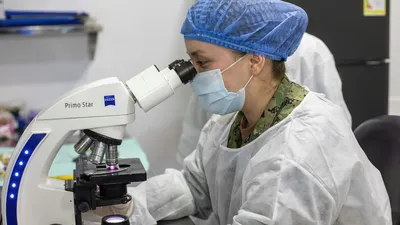 Researcher at a microscope reviewing the latest bladder health research in a laboratory