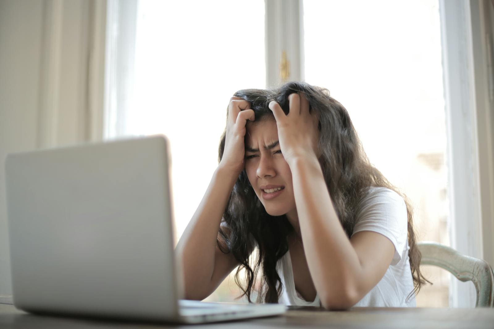 Woman looking anxious at her desk, illustrating how stress can contribute to UTI risk through cortisol and immune suppression
