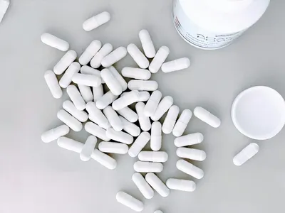 D-mannose powder and capsules on a wooden surface, a supplement studied for interstitial cystitis