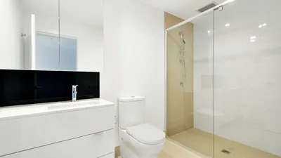 White toilet in a clean bathroom, where the double voiding technique helps empty the bladder fully