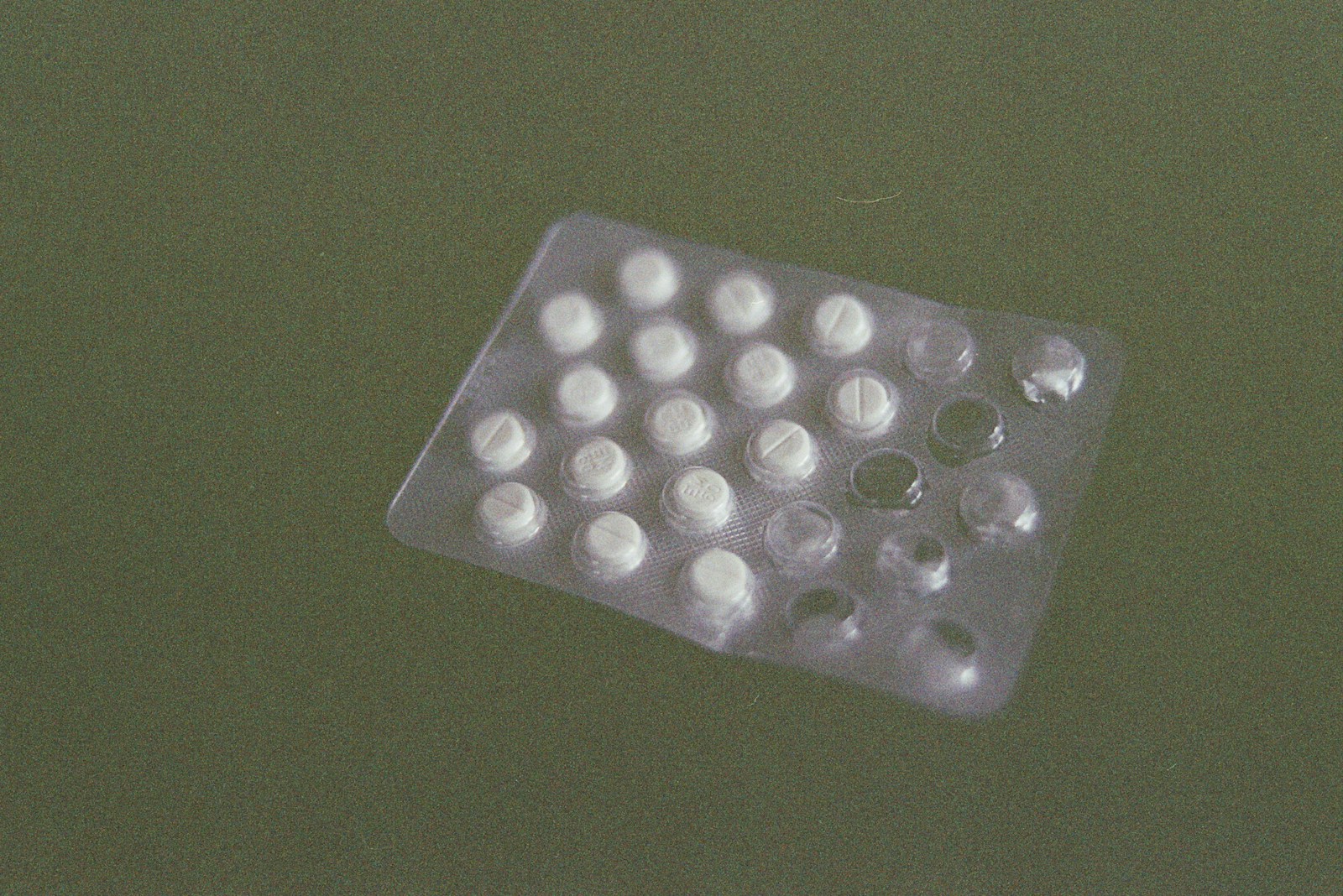 Methenamine hippurate tablets (Hiprex) on a clinical desk beside a urine sample pot, used for recurrent UTI prevention