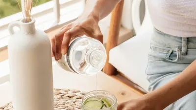 Woman drinking a glass of water, a simple habit to help prevent UTI after sex