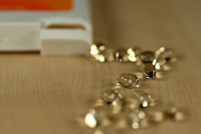 Vitamin D softgel capsules spilled on a table, a common supplement for bladder health