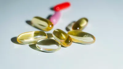 Vitamin D capsules and a blood test tube on a desk, illustrating testing for vitamin D deficiency and urinary incontinence risk
